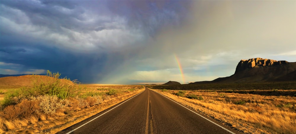 road between open field near mountain