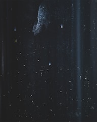 Abstract dark graphite patterns with faint central glow and low contrast particles.