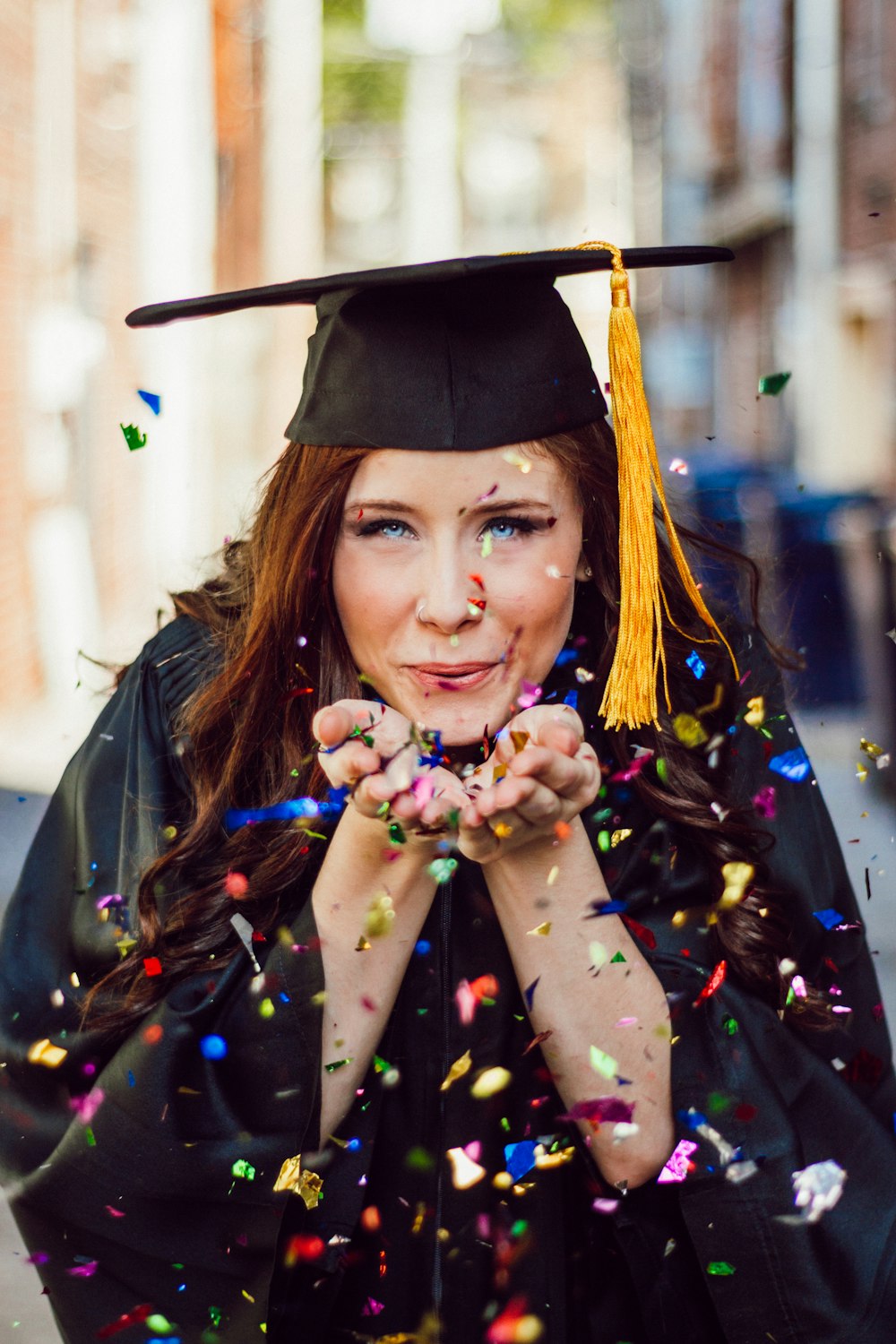 Mujer soplando confeti de colores variados