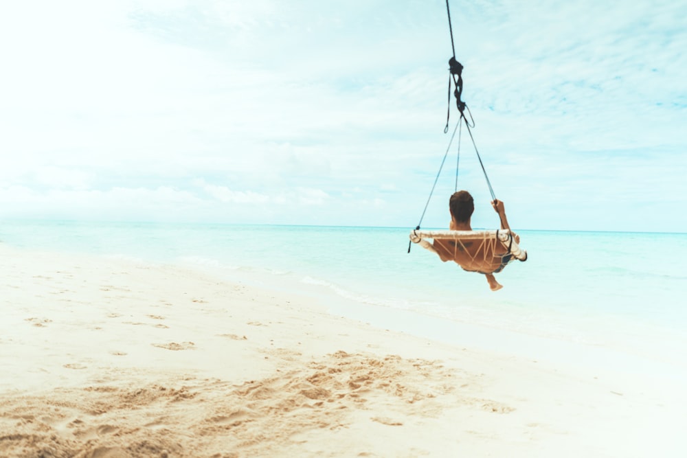 man swing beside body of water