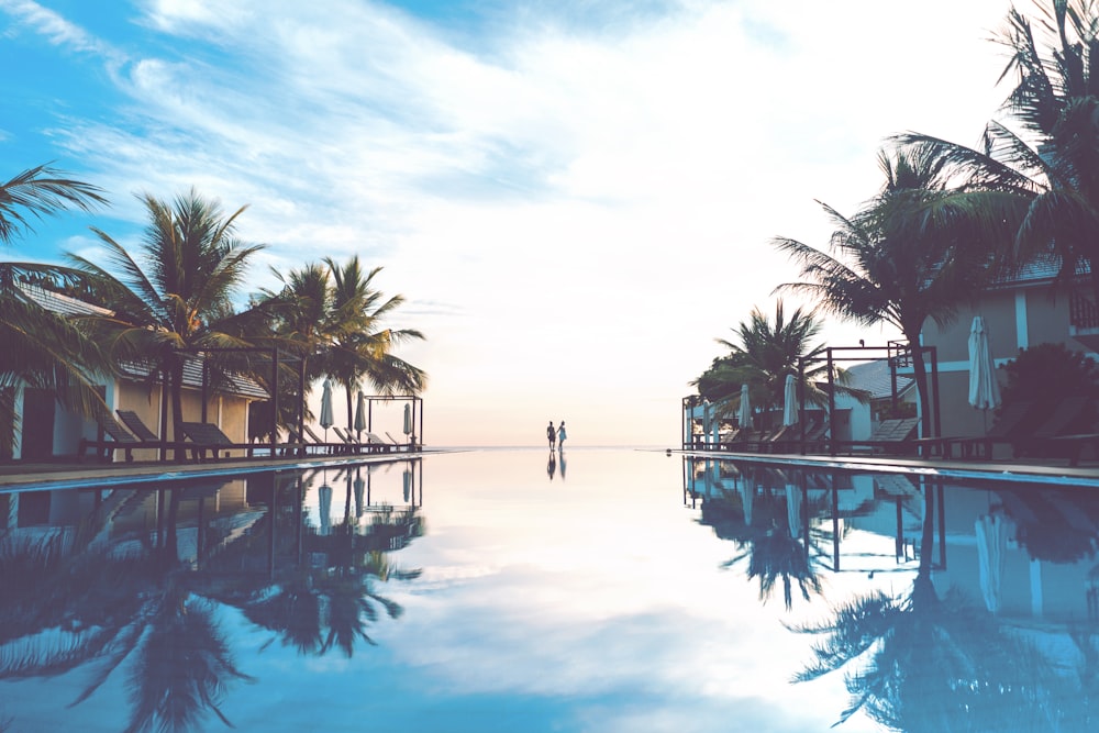 zwei Personen stehen neben dem Swimmingpool