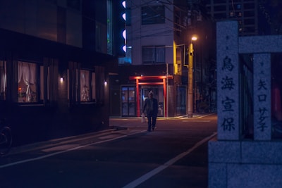 A quiet street at dusk with glowing street lamps and a lone figure walking thoughtfully.