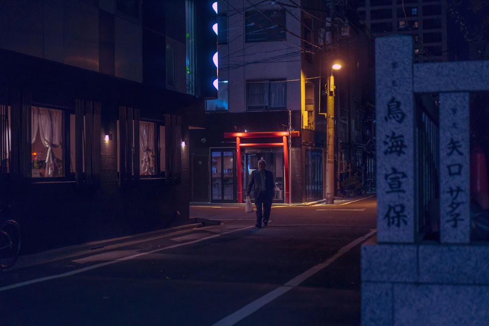man walking in the road at nighttime