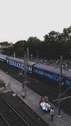 A friendly driver helping tourists with their bags near a railway station.