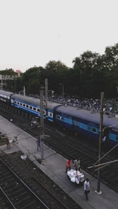 A friendly driver helping tourists with their bags near a railway station.