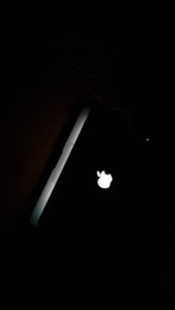 MacBook with a glowing Apple logo sitting on a clean workbench surrounded by repair tools.