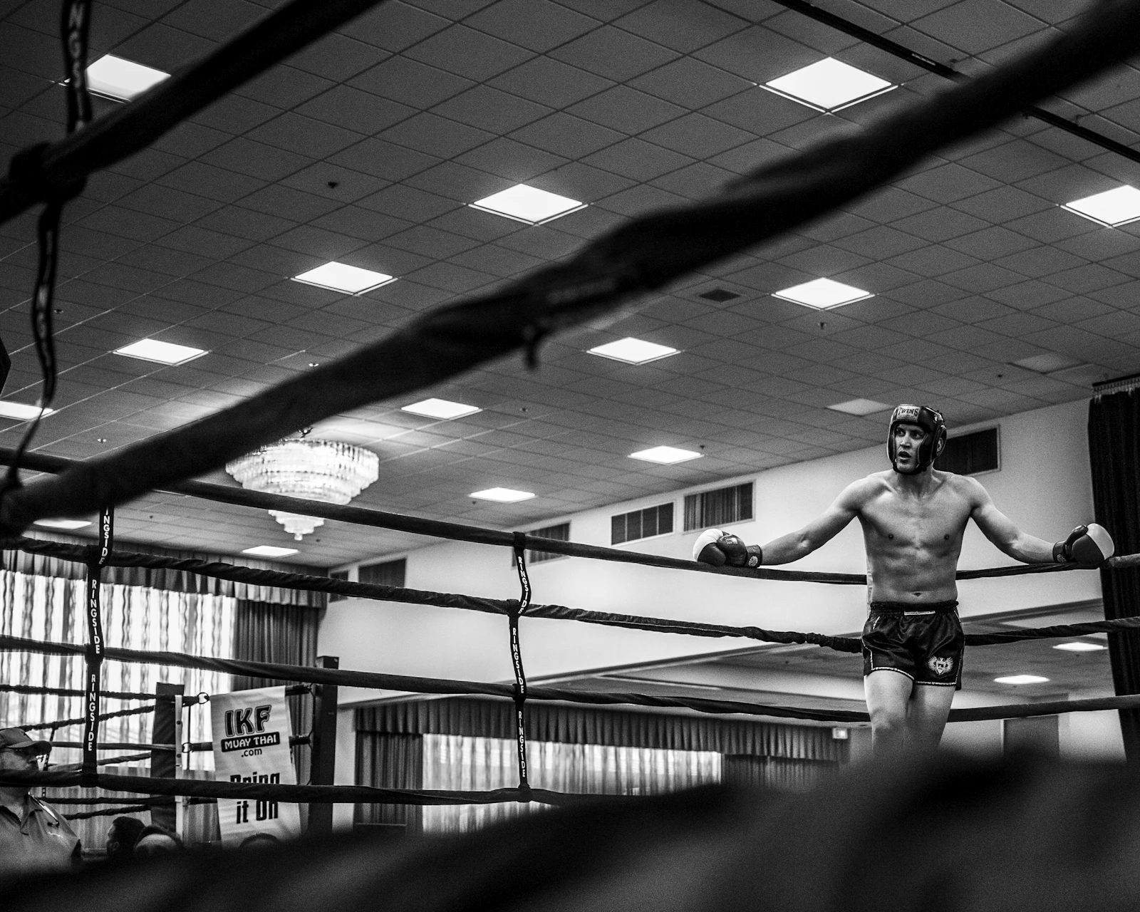 A fighter reflecting beside a boxing ring