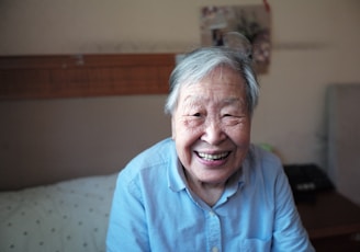 woman in blue button-down shirt smiling in front of camera