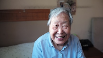 woman in blue button-down shirt smiling in front of camera