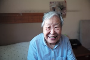 woman in blue button-down shirt smiling in front of camera