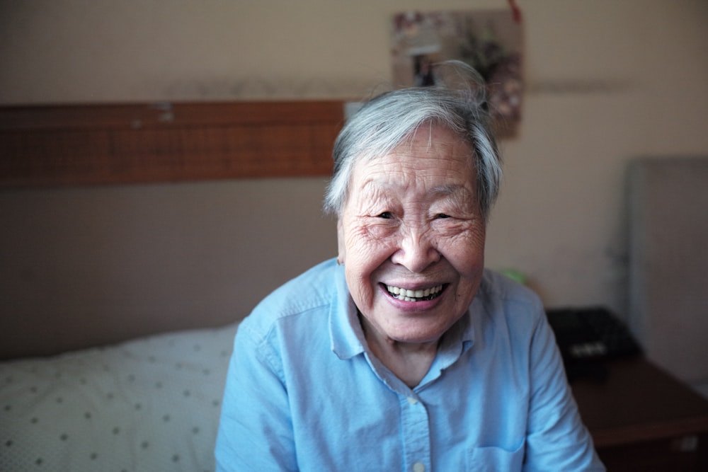 woman in blue button-down shirt smiling in front of camera