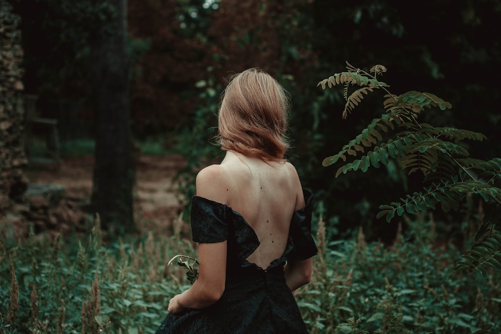 숲에 서 있는 여성의 선택적 초점 사진