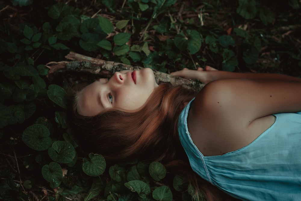 woman wearing blue top laying on grass