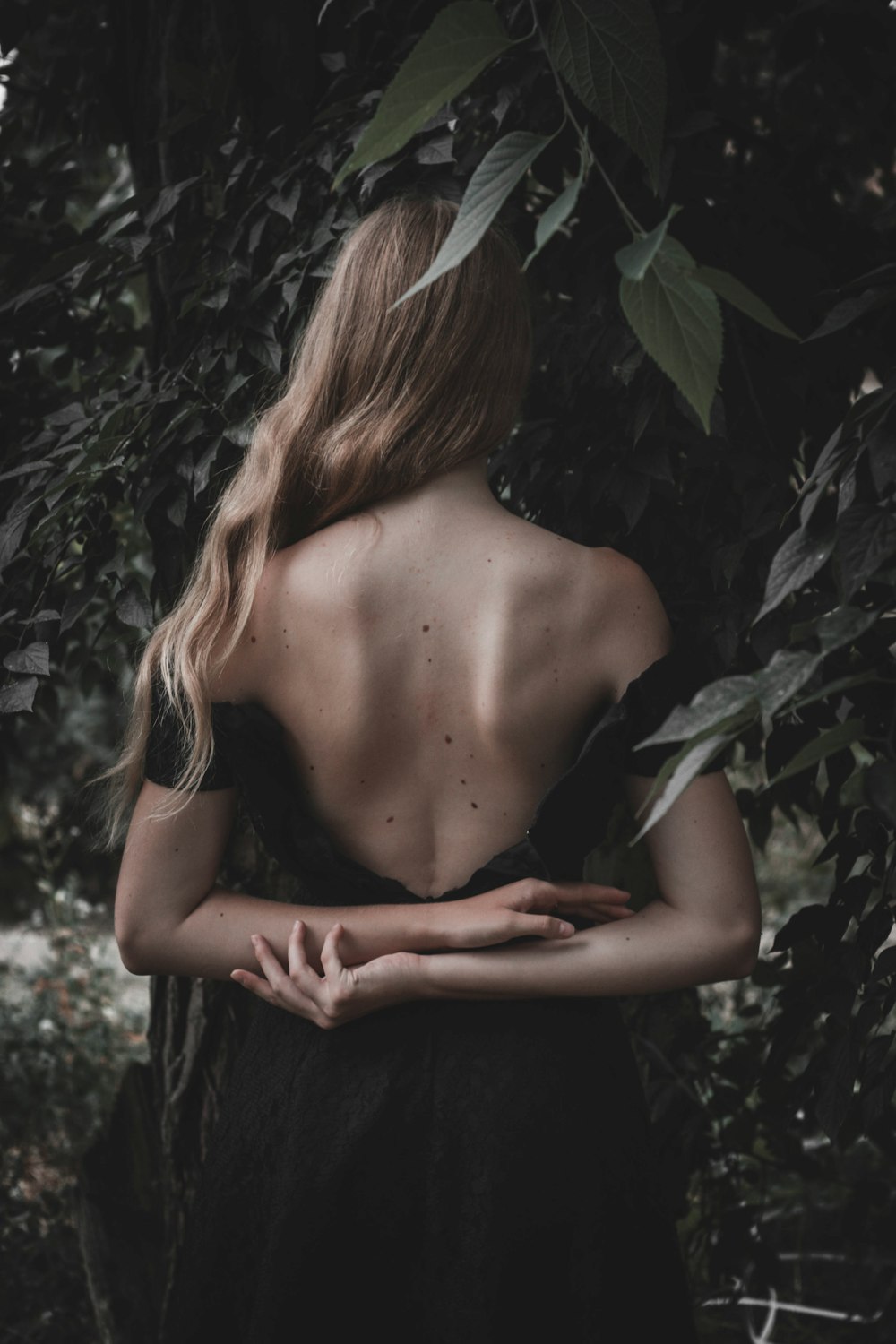 woman wearing backless dress near leaves