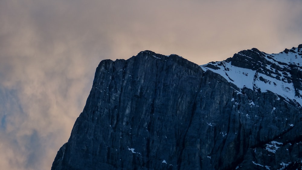 Berg mit Schnee unter bewölktem Himmel