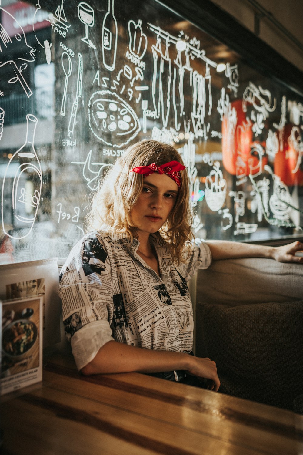 woman sitting behind graffiti glass wall