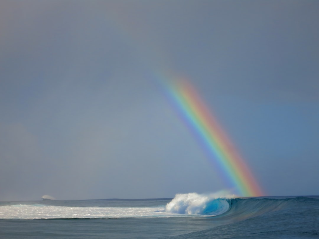 sea wave beside rainbow, I was lucky enough to be in Tahiti during the Billabong pro surf comp in 2014. This was taken on the finals day, moments after Medina took down Kelly Slater. It was probably the most amazing weeks of my life. I still canβt believe I saw this scene with my mortal eyes and I especially love the cheeky little wave in the background. This photo makes me feel lucky to be alive!