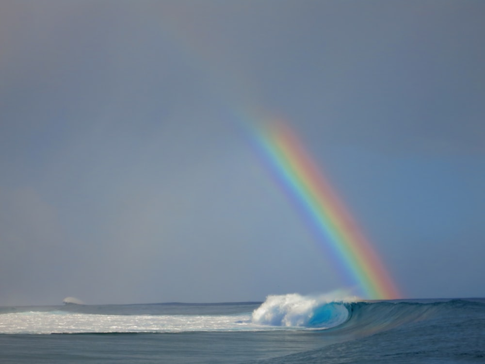 onda del mare accanto all'arcobaleno