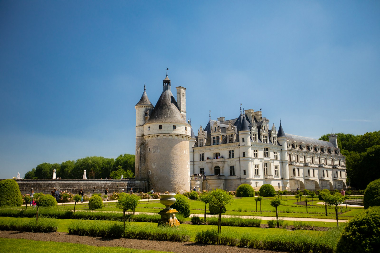 A historic chateau standing behind formal grounds