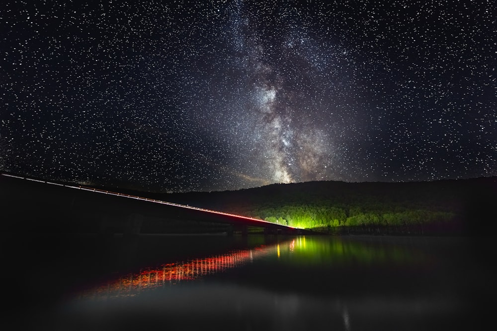 silhouette of mountain with concrete bridge during nighttime