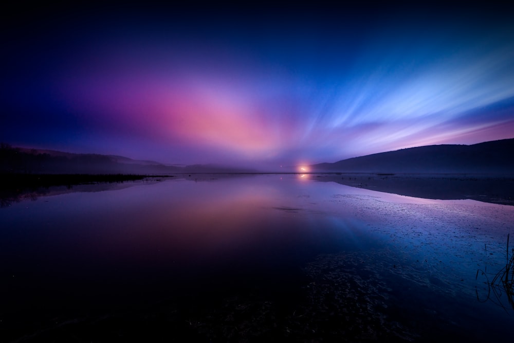 landscape photography of body of water under dramatic sky