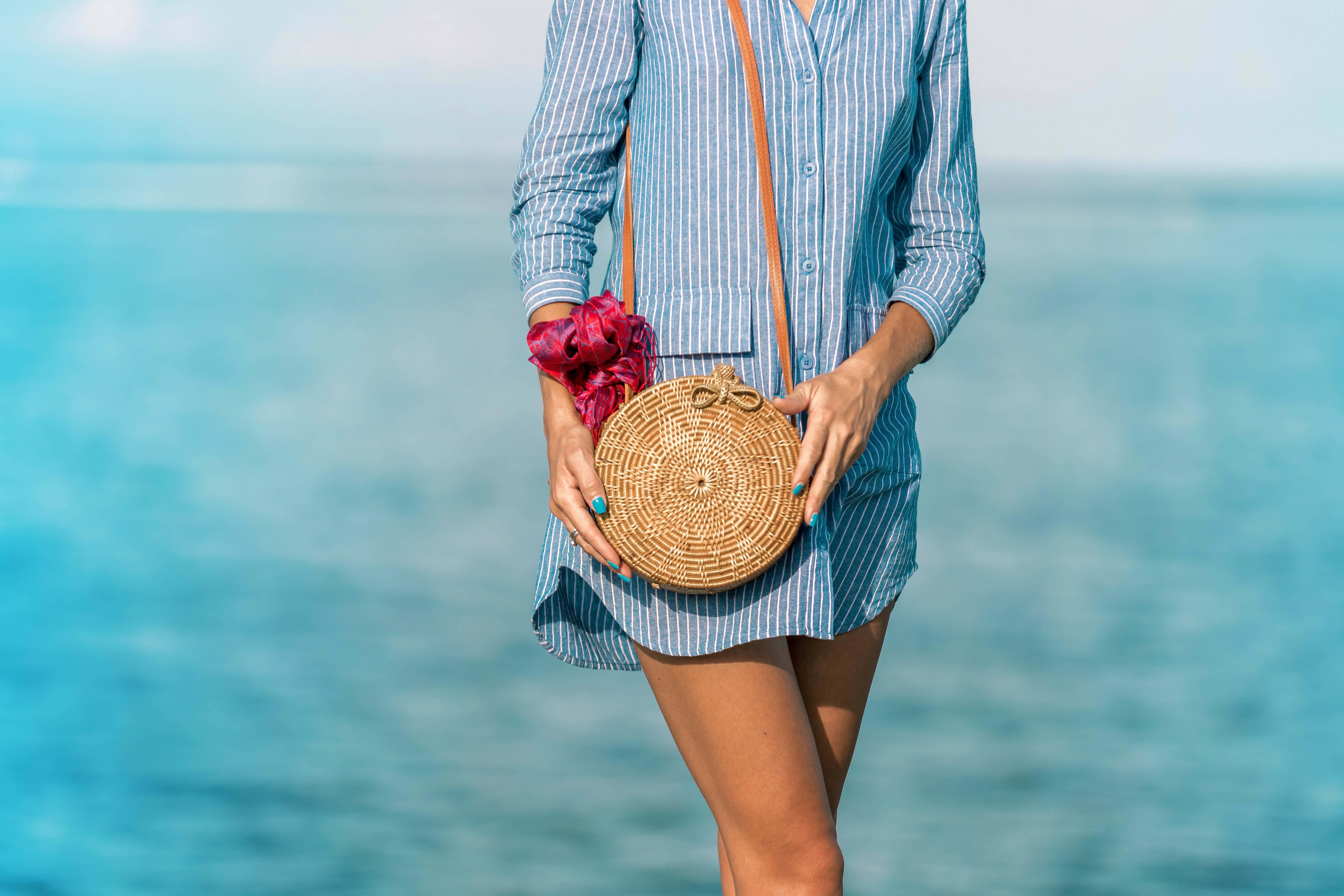 Woman hands with fashionable stylish rattan bag