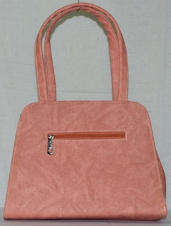 A stylish pink handbag displayed on a soft purple background.