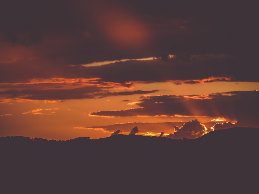 the sun is setting over a mountain range