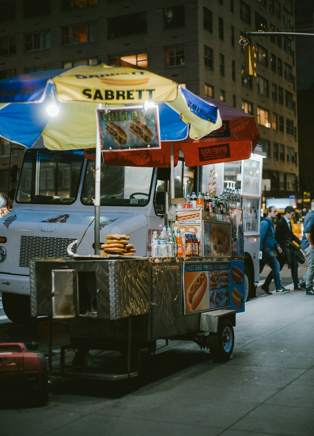 gray food stall with umbrella near vehicle