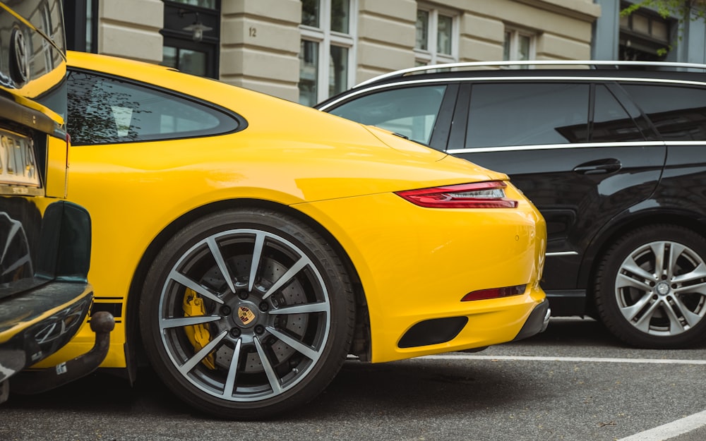 two yellow and black vehicles parked near gray concrete building