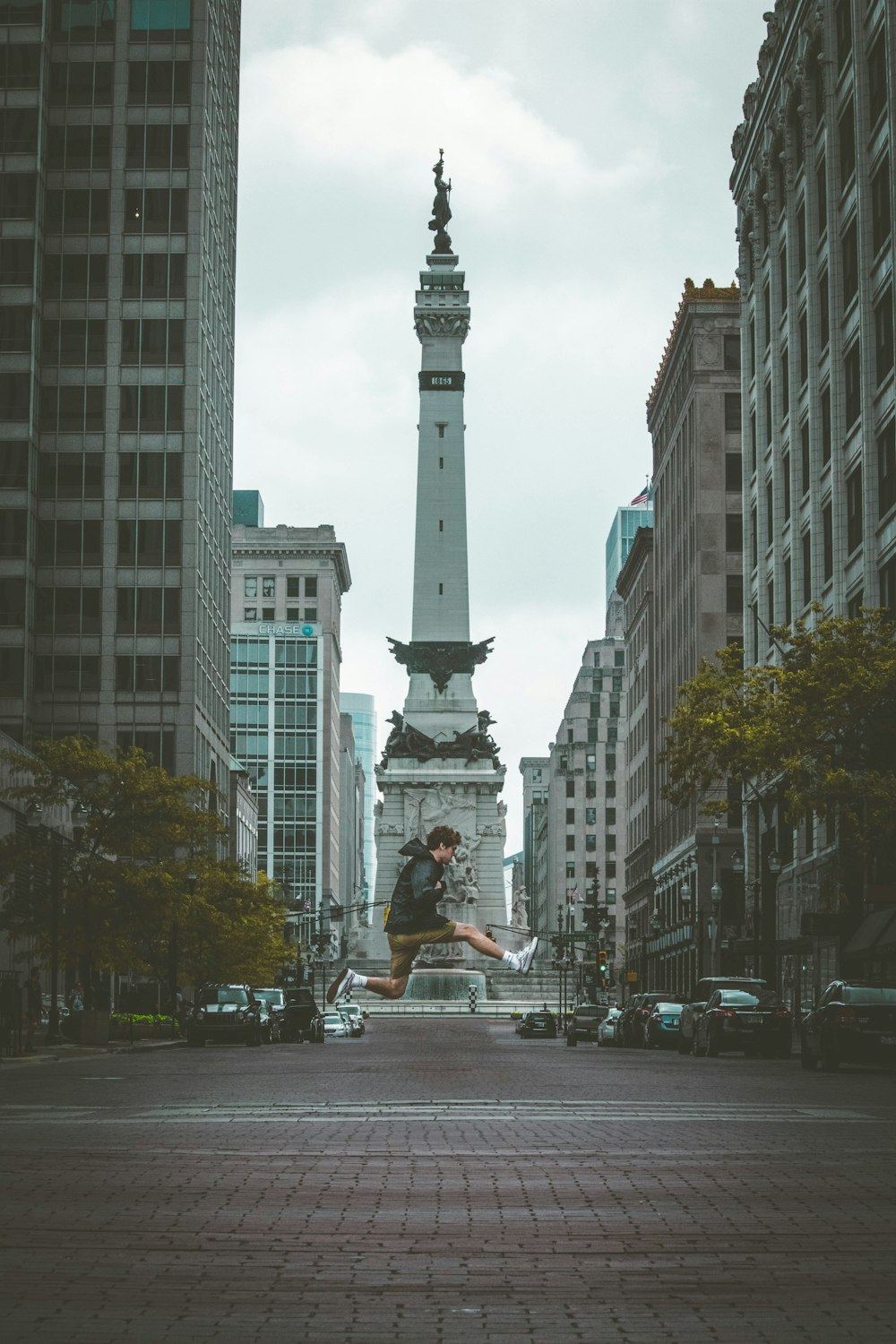 photo de saut d’homme avec un fond de monument entre les bâtiments