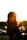 woman standing in front of gray metal fence during sunset