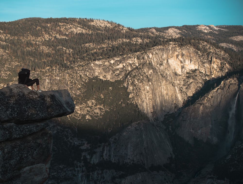 person sitting on cliff