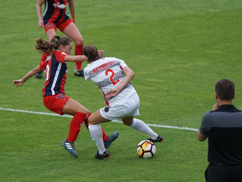 women playing soccer in an open field