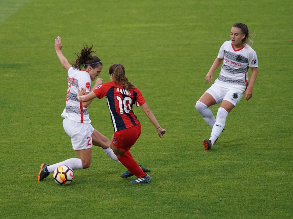 three women playing soccer