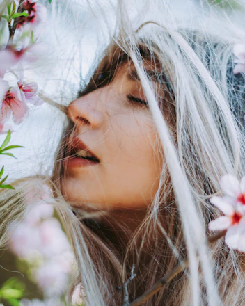 Softly lit close-up of flowing hair with delicate flower petals resting gently on strands.