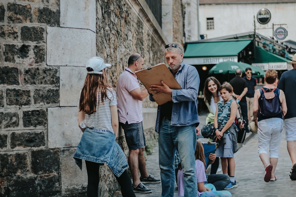 man holding clipboard talking to girl