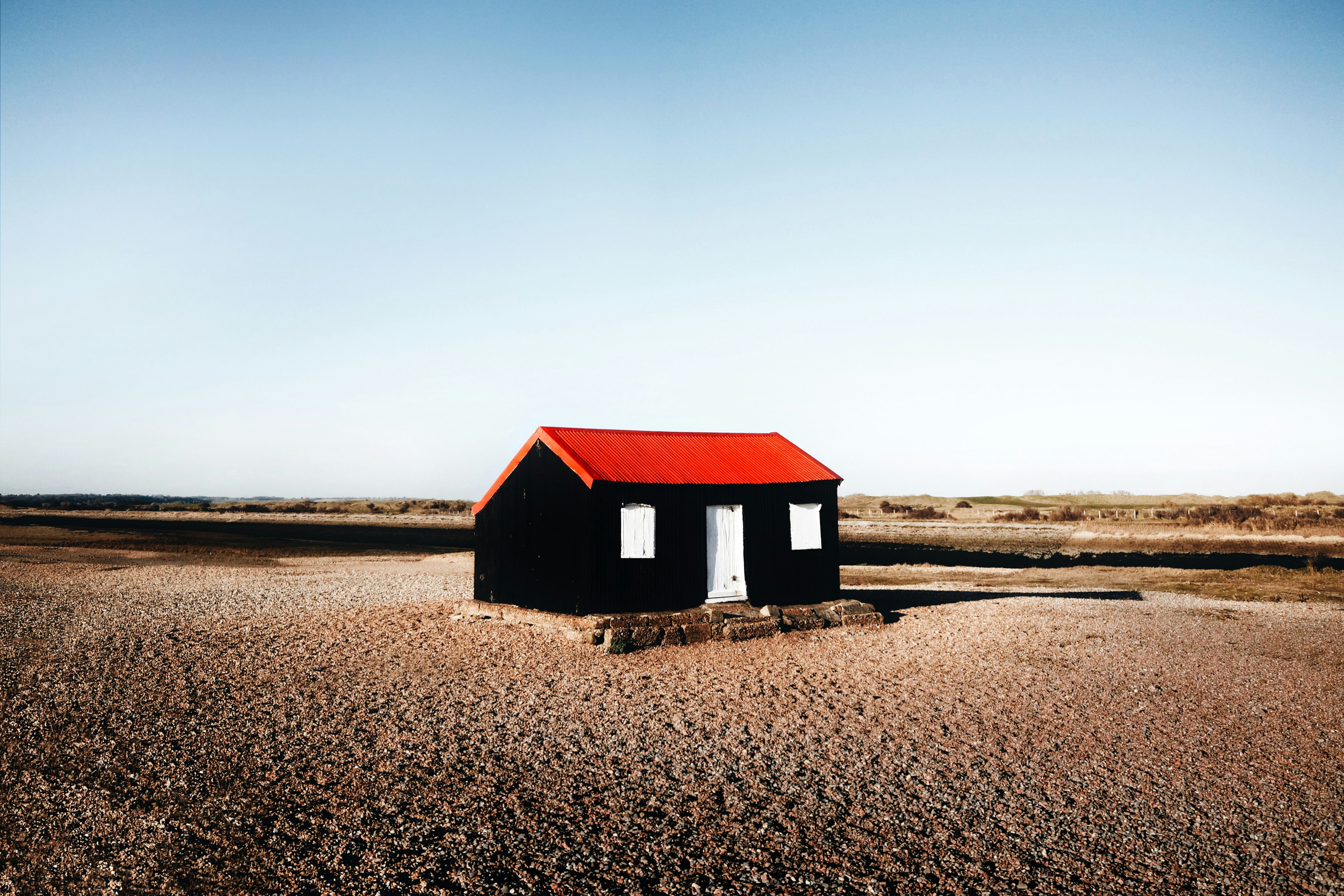 black and red wooden house in the middle of nowhere