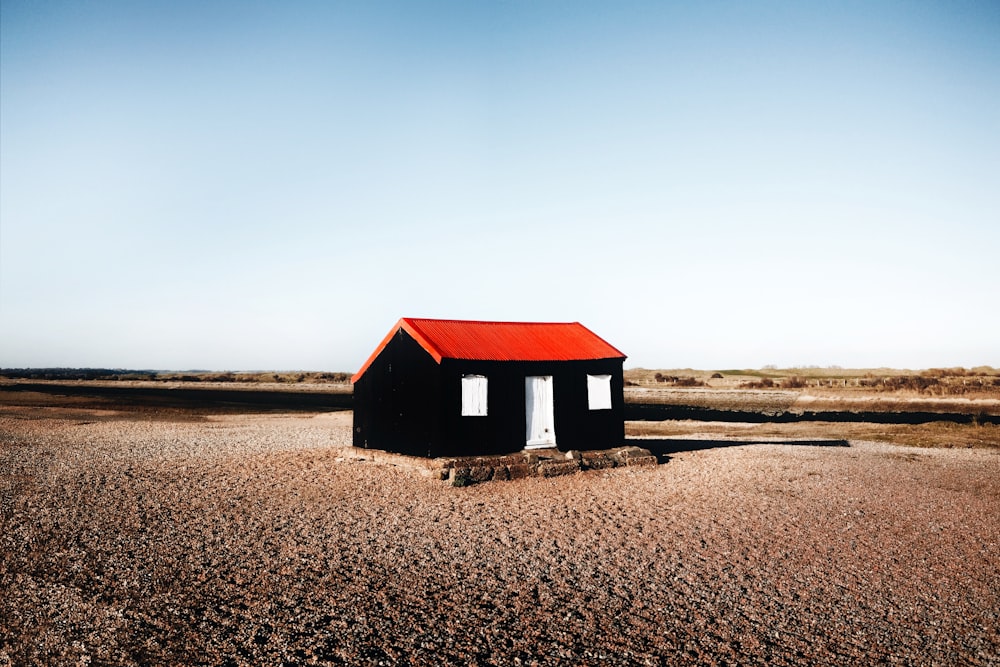 black and red wooden house in the middle of nowhere