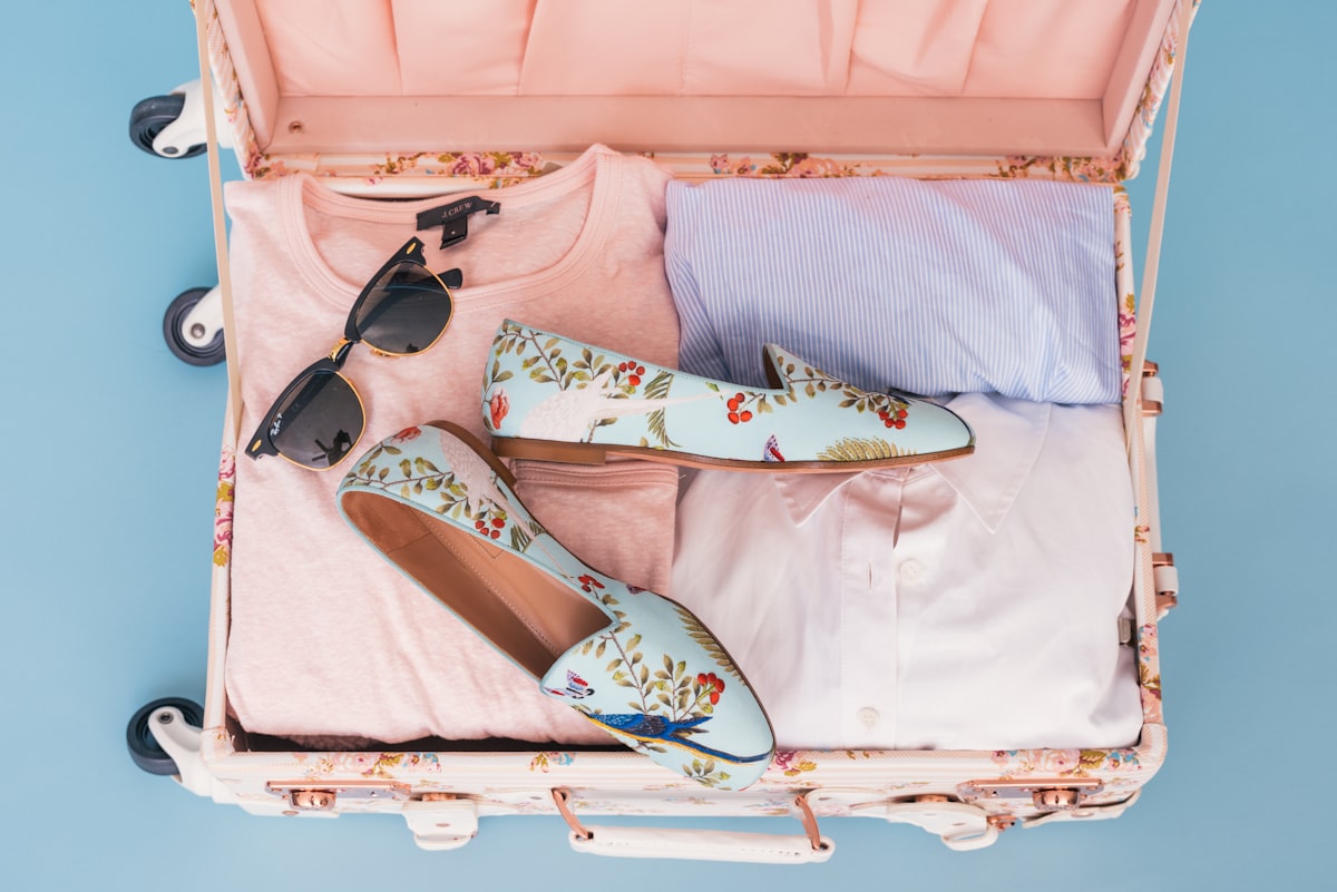 Clothing items and pair of shoes in luggage
