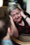 A warm portrait of a smiling elderly woman being gently cared for by a compassionate caregiver in a cozy home setting.