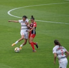 women playing soccer on field