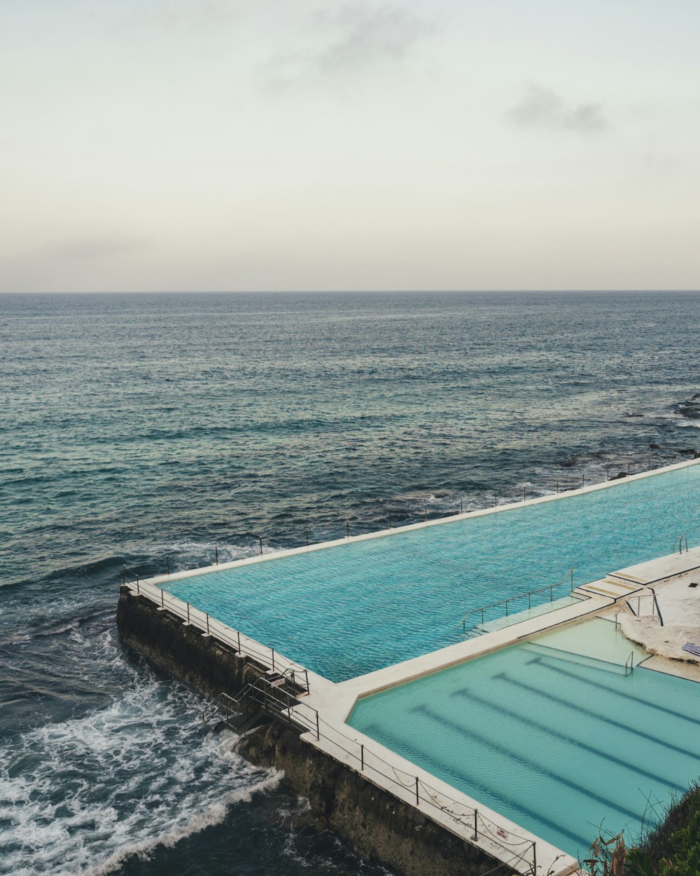 aerial photo of infinity pool beside body of watet