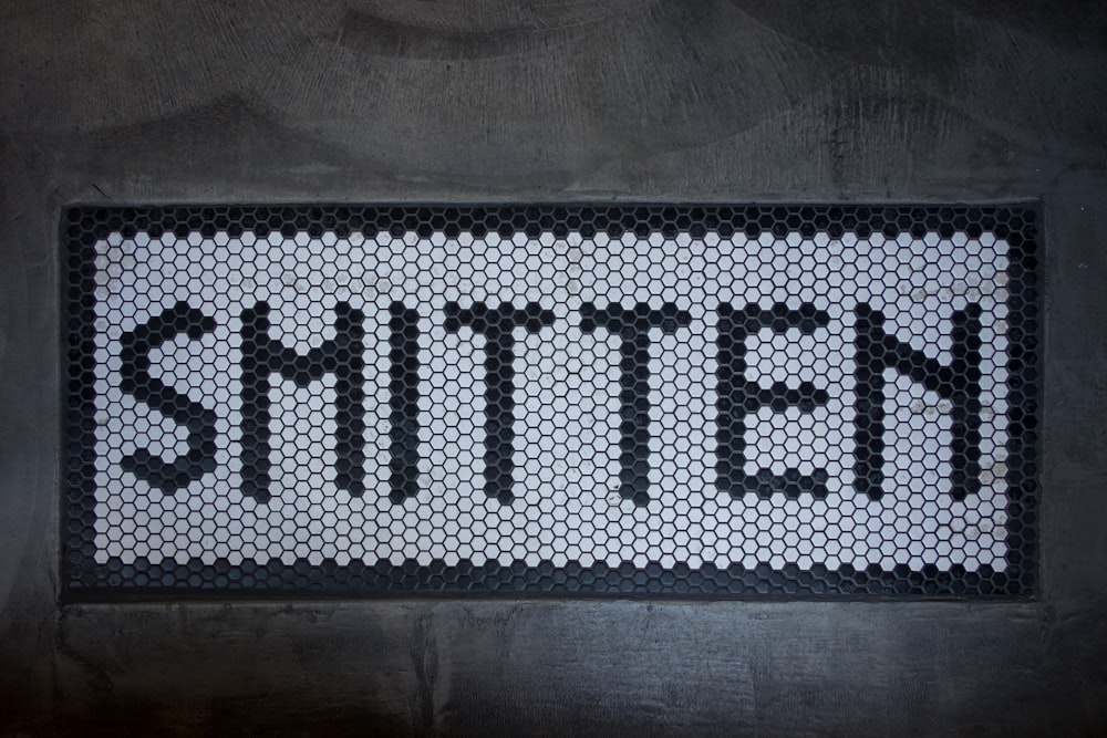 a black and white sign that says smitten
