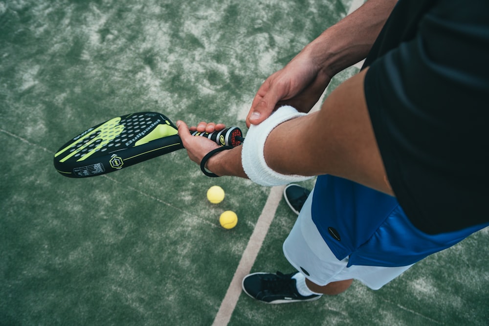 personne tenant une raquette de tennis