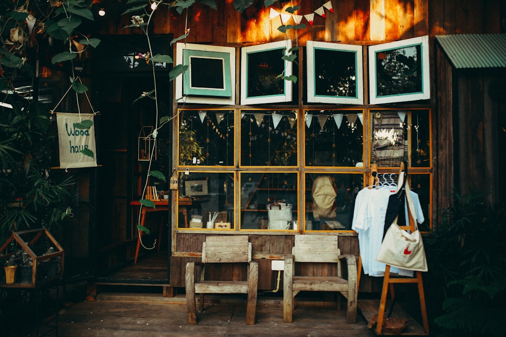 two brown wooden armchairs in front of glass window