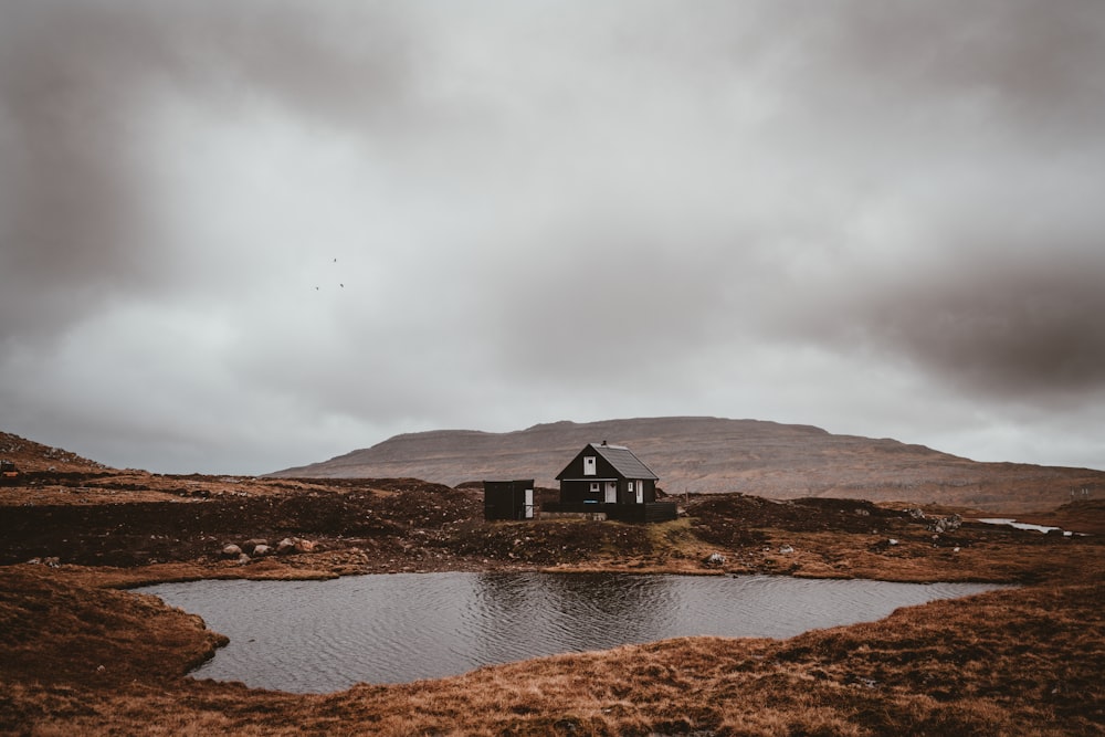 black house near a pond