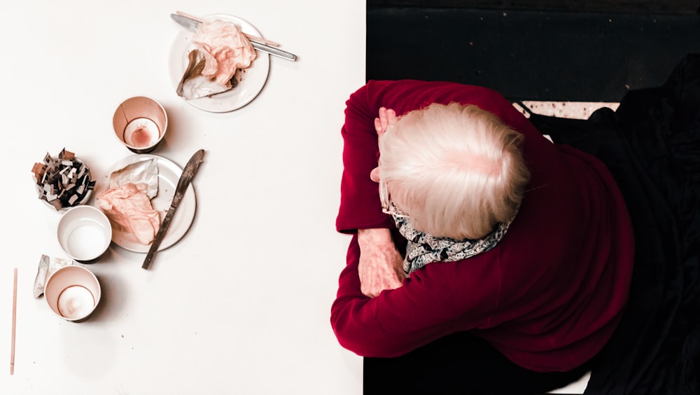 woman resting her hand on white table