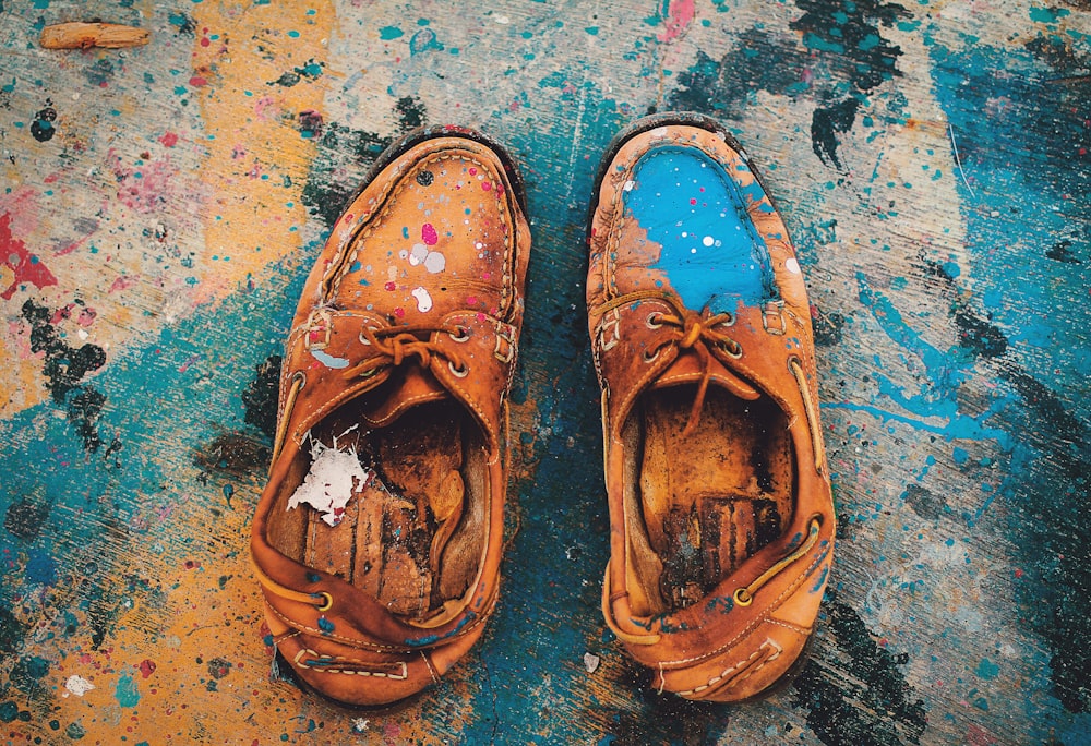 brown leather shoes on blue and white concrete floor