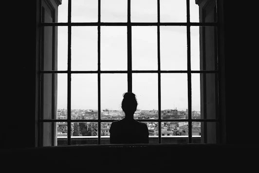 woman standing in front glass window